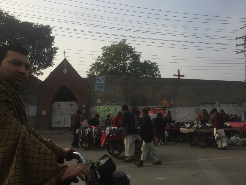 Juxtaposition of a Christian church near the Walled City behind a high security wall and the daily activities unfolding in front of it.